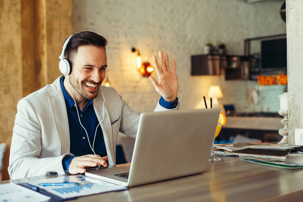 Male English teacher waving on a conference call